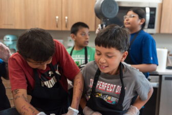 Oglala Lakota children participate in a cooking class during the Oyate Ta Kola Ku Summer Rec Program at Pine Ridge Indian Reservation