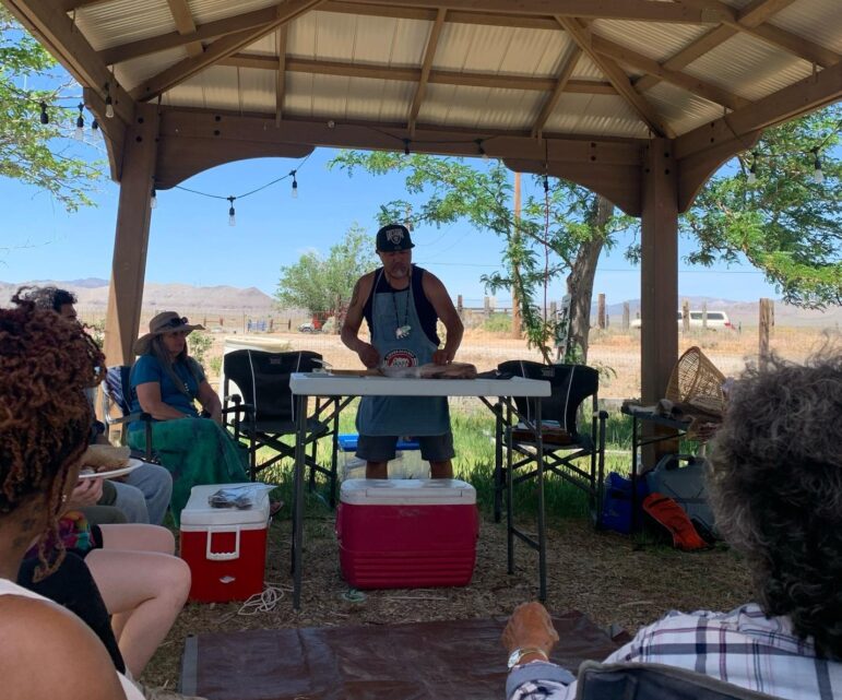 Elder Delmar Stevens demonstrates how to fillet trout using traditional methods at the "Journey of a Water Protector" event.