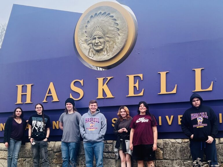 Native students on a field trip pose in front of the Haskell College sign, part of Donald King's Dreamstarter program.