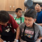 Oglala Lakota children participate in a cooking class during the Oyate Ta Kola Ku Summer Rec Program at Pine Ridge Indian Reservation