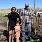 Family standing in a newly planted garden during the Medicine Root Gardening Program on the Pine Ridge Reservation