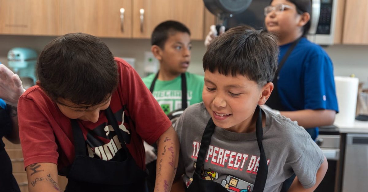 Oglala Lakota children participate in a cooking class during the Oyate Ta Kola Ku Summer Rec Program at Pine Ridge Indian Reservation