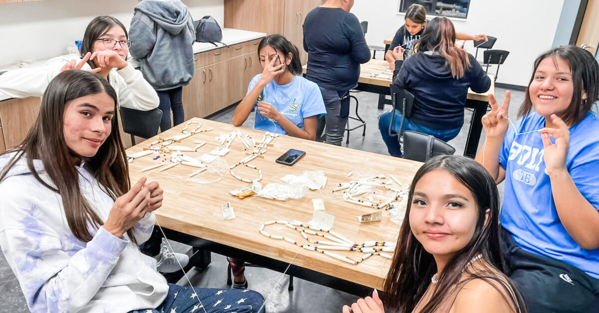 Children and adults are sewing at the Pine Ridge native american community center